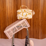 Trousse vanity Fauve Rose sur une caisse rose renversée, soins posés au sol