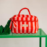 Gros plan sur la trousse vanity Pacha Tomato de Byzantine, poignée et nœud rayés